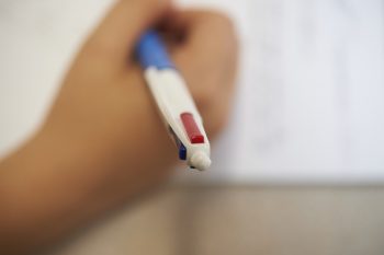 image of pen and hand writing